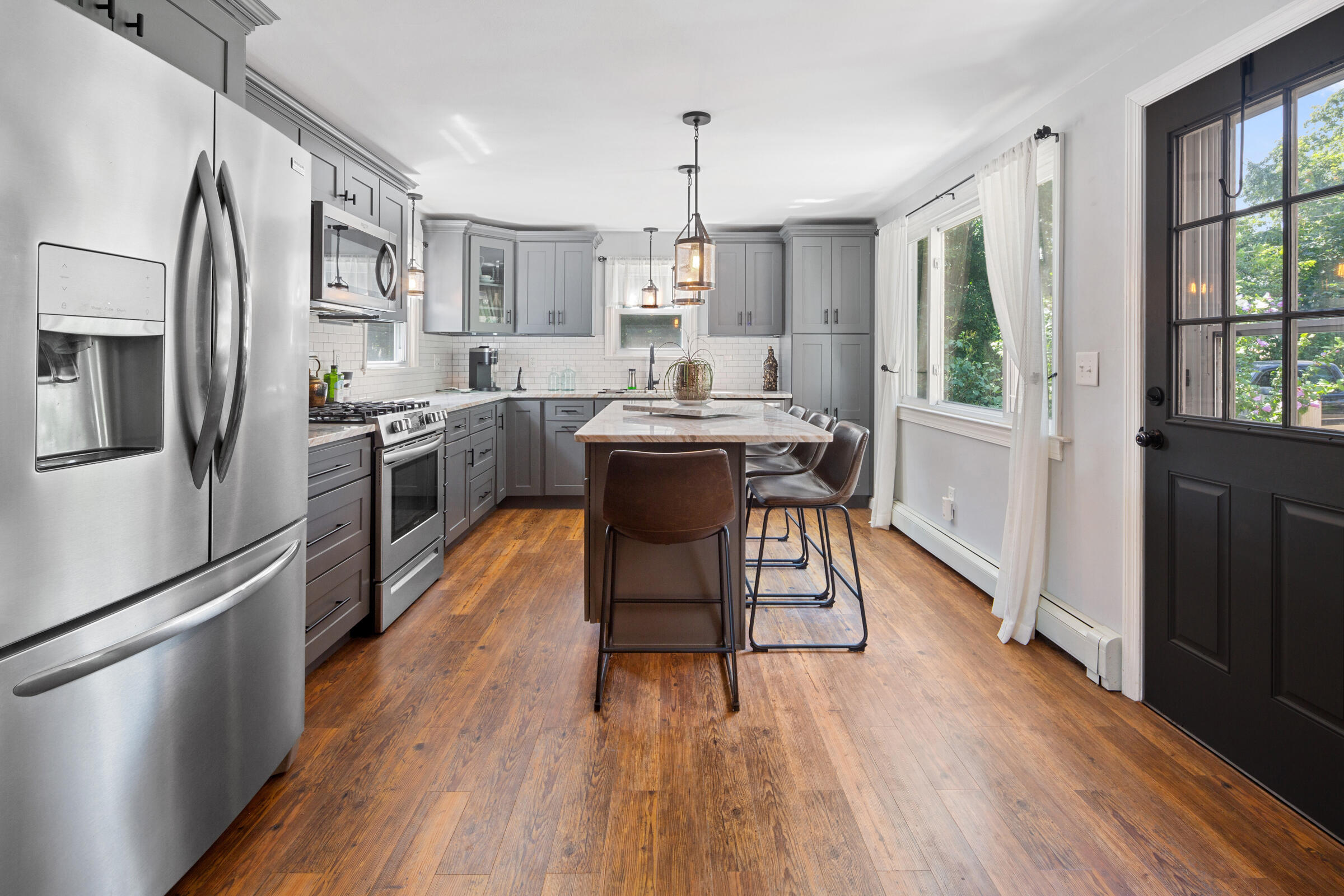 31 Soundview Road Centerville, MA 02632 - Photo 7 of 50 a kitchen with stainless steel appliances a dining table chairs refrigerator and sink
