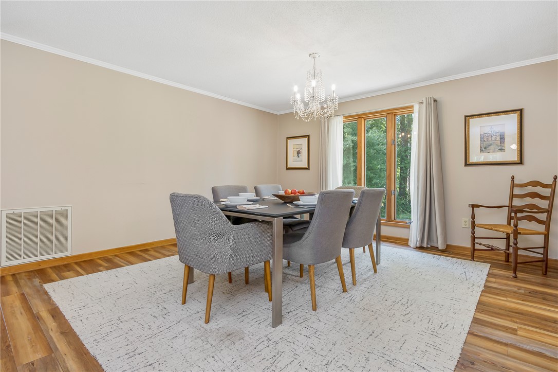 207 Laurel Ridge Road Anderson, SC 29621 - Photo 12 of 50 A classic chandelier illuminates this elegant dining area, boasting generous natural light through its expansive window.