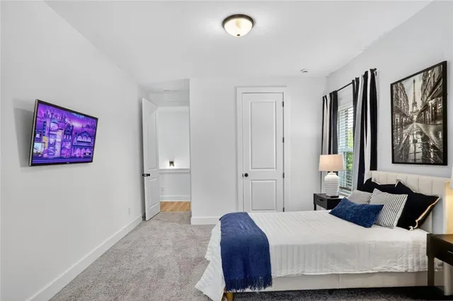 a bedroom with a bed and painting on the wall