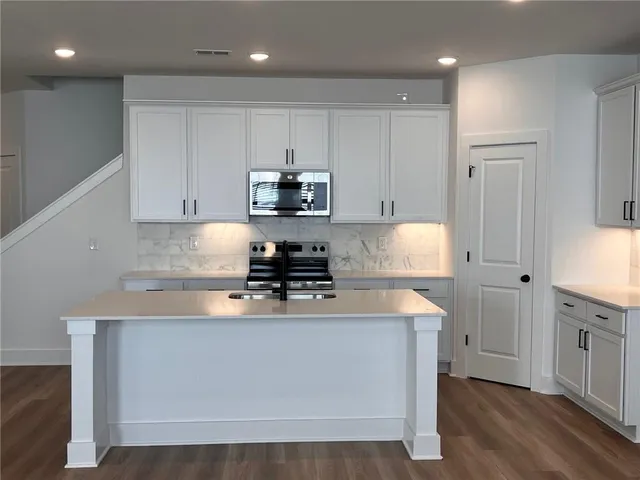 a large kitchen with stainless steel appliances lots of counter top space