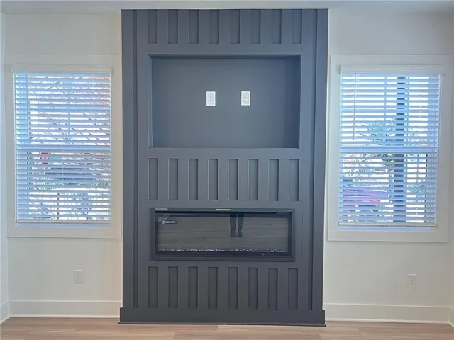 a view of kitchen with stainless steel appliances granite countertop a stove top oven a sink dishwasher a dining table and chairs with wooden floor
