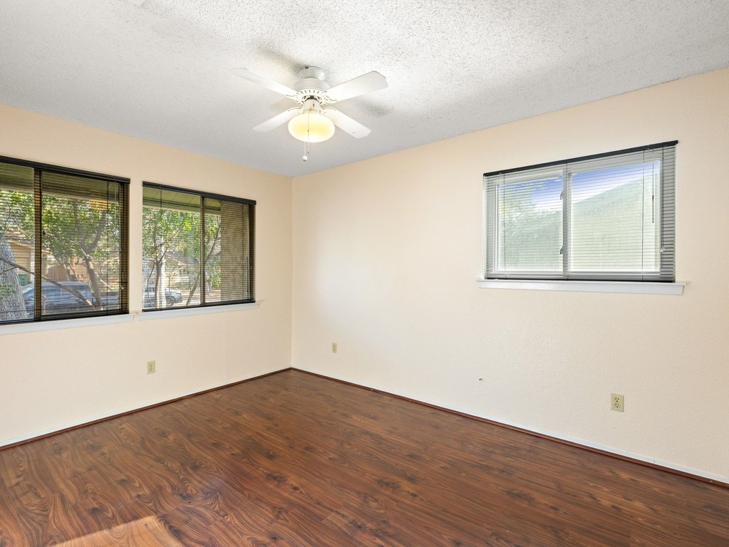 4711 Fieldstone Drive Austin, TX 78735 - Photo 18 of 40 a view of an empty room with wooden floor and a window
