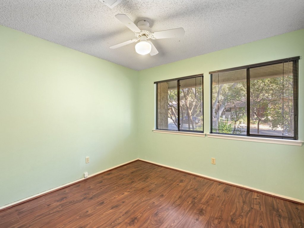 4711 Fieldstone Drive Austin, TX 78735 - Photo 18 of 40 Unfurnished room featuring dark wood finished floors, a textured ceiling, and a ceiling fan