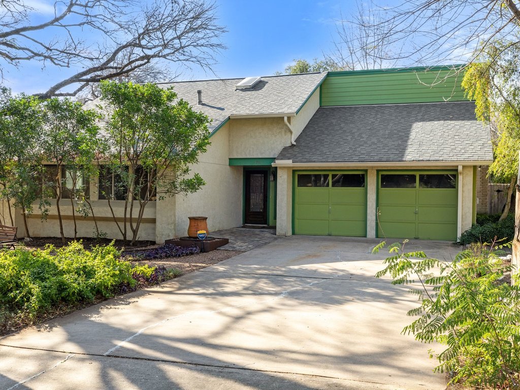 4711 Fieldstone Drive Austin, TX 78735 - Photo 5 of 40 View of front of house featuring roof with shingles, driveway, an attached garage, and stucco siding