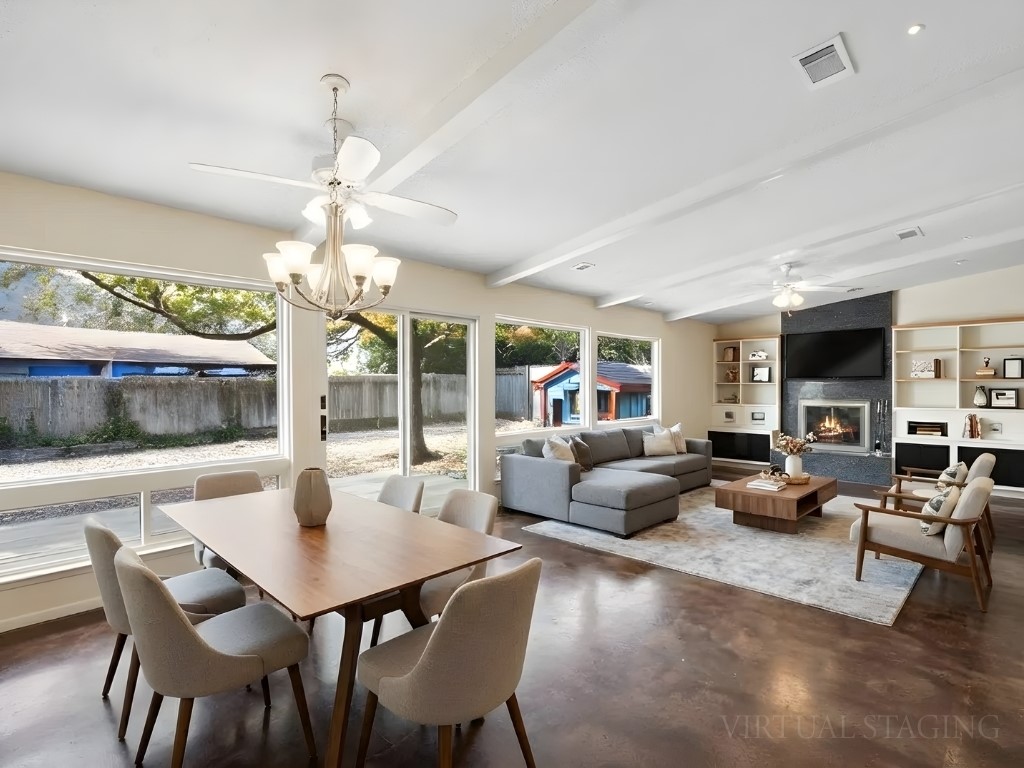 4711 Fieldstone Drive Austin, TX 78735 - Photo 6 of 40 Dining space with a ceiling fan, built in shelves, concrete flooring, a large fireplace, and beam ceiling