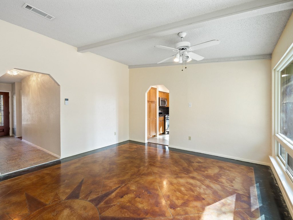 4711 Fieldstone Drive Austin, TX 78735 - Photo 10 of 40 Empty room with concrete flooring, arched walkways, a textured ceiling, ceiling fan, and beamed ceiling
