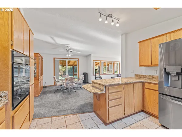 a large kitchen with kitchen island granite countertop a sink and cabinets