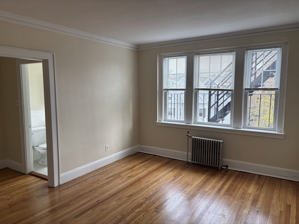 50 Broadway, Unit 46 Beverly, MA 01915 - Photo 2 of 7 an empty room with wooden floor and windows