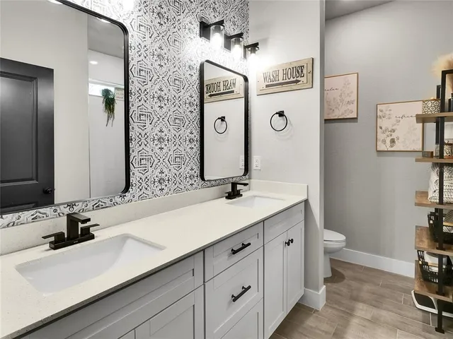 a bathroom with a sink a toilet and a mirror