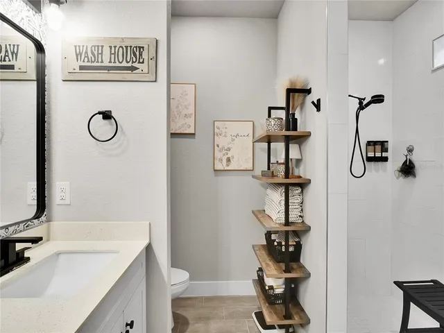 a bathroom with a granite countertop sink a toilet and a mirror
