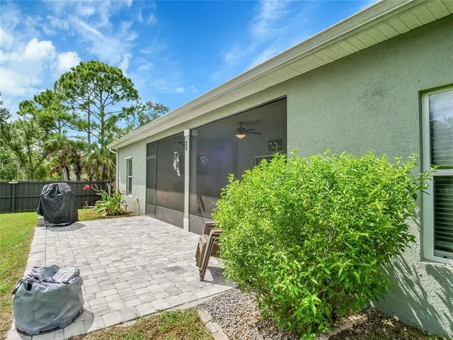 a view of a backyard with couches potted plants and floor to ceiling window