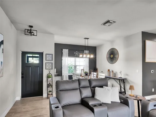 a living room with furniture kitchen view and a window