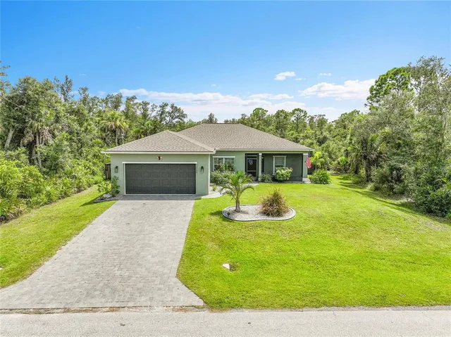 a front view of a house with yard and green space