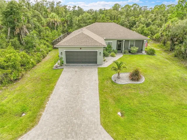a aerial view of a house with swimming pool and trees in the background