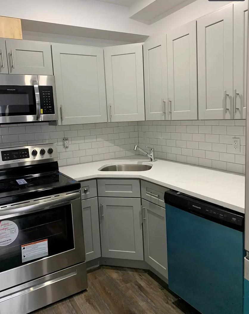 37-28 104th Street Queens, NY 11368 - Photo 3 of 11 a kitchen with stainless steel appliances granite countertop a sink stove and microwave