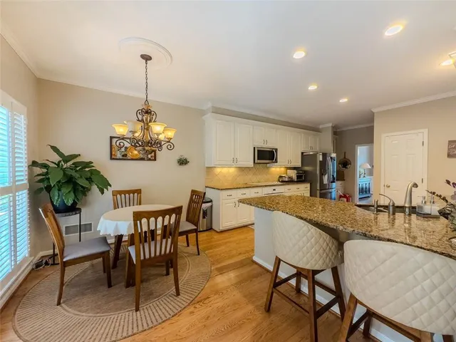 a dining room filled chandelier and kitchen view