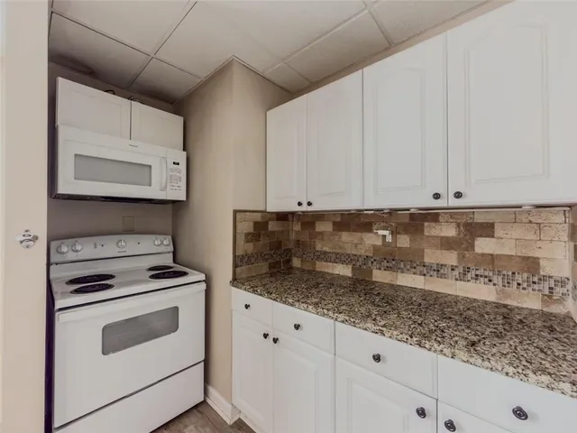 a kitchen with granite countertop white cabinets stainless steel appliances and sink