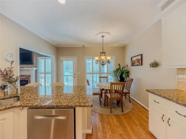 a kitchen with granite countertop a table and chairs in it