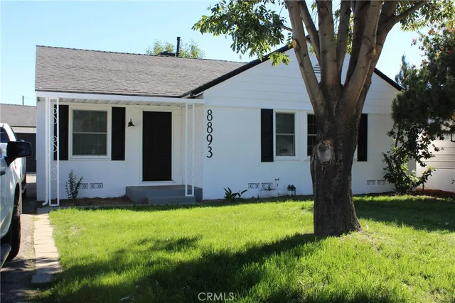 a front view of a house with yard and green space