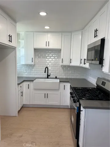 a kitchen with cabinets appliances a sink and a counter top space