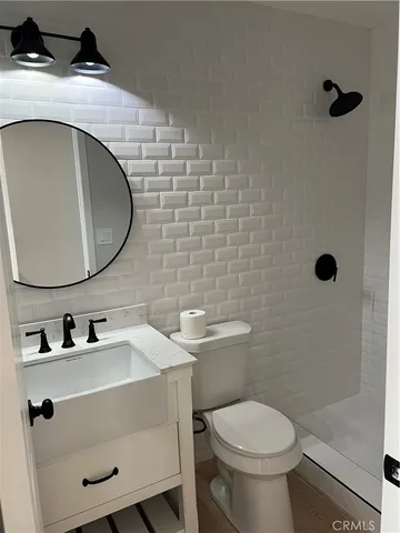 a bathroom with a toilet sink vanity and mirror