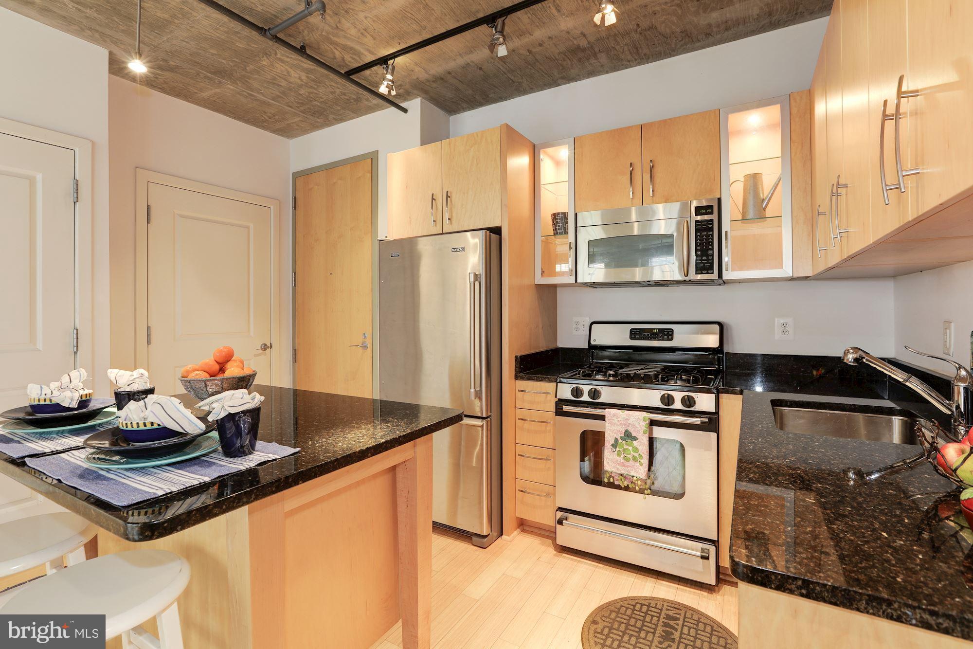 1444 Church Street Northwest, Unit 206 Washington, DC 20005 - Photo 5 of 22 a kitchen with stainless steel appliances granite countertop a sink stove and refrigerator