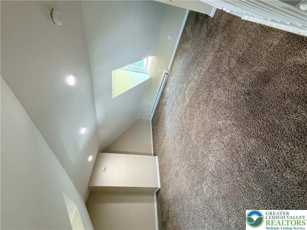 718 Ferry Street Easton, PA 18042 - Photo 23 of 37 Natural light filters through the skylight, illuminating the comfortable carpeted flooring and high ceilings.
