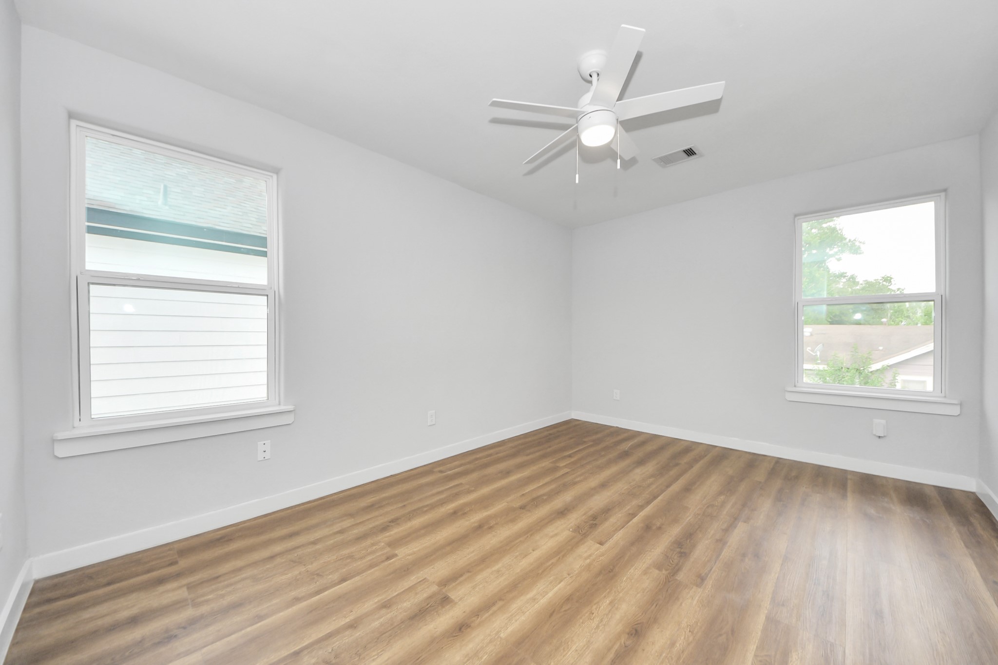 6609 Bacher Street, Unit A Houston, TX 77028 - Photo 26 of 33 an empty room with wooden floor windows and fan