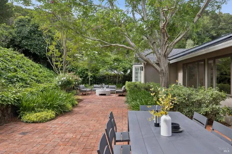 a view of a patio with plants and chairs