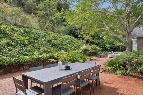 a view of an outside dining space with a table and chairs