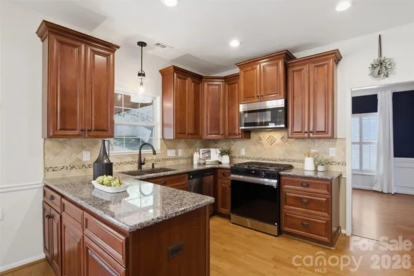 a kitchen with stainless steel appliances granite countertop a sink stove and microwave