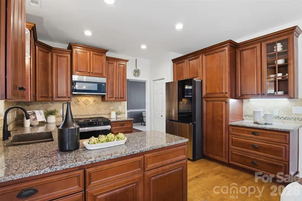 a kitchen with stainless steel appliances granite countertop a refrigerator and a sink