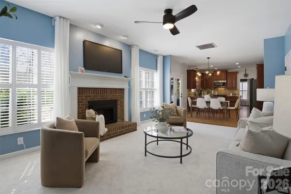 a living room with furniture a fireplace and a flat screen tv