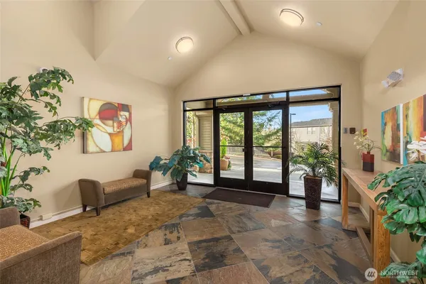 a living room with furniture large window and potted plants