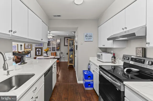 a kitchen with kitchen island a sink stove top oven and cabinets