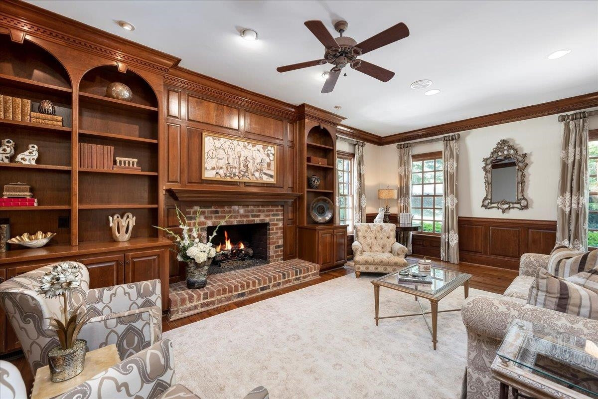 1213 Marlowe Road Raleigh, NC 27609 - Photo 11 of 30 Large Room with Wood Paneling, Hardwood Floors, Gas Fireplace, Custom Built-Ins with Storage, Arched Doorways, Heavy Crown Molding Den/Family/Great Room
