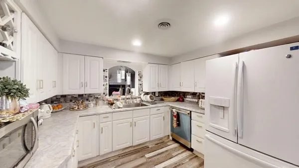 a kitchen with granite countertop white cabinets and stainless steel appliances