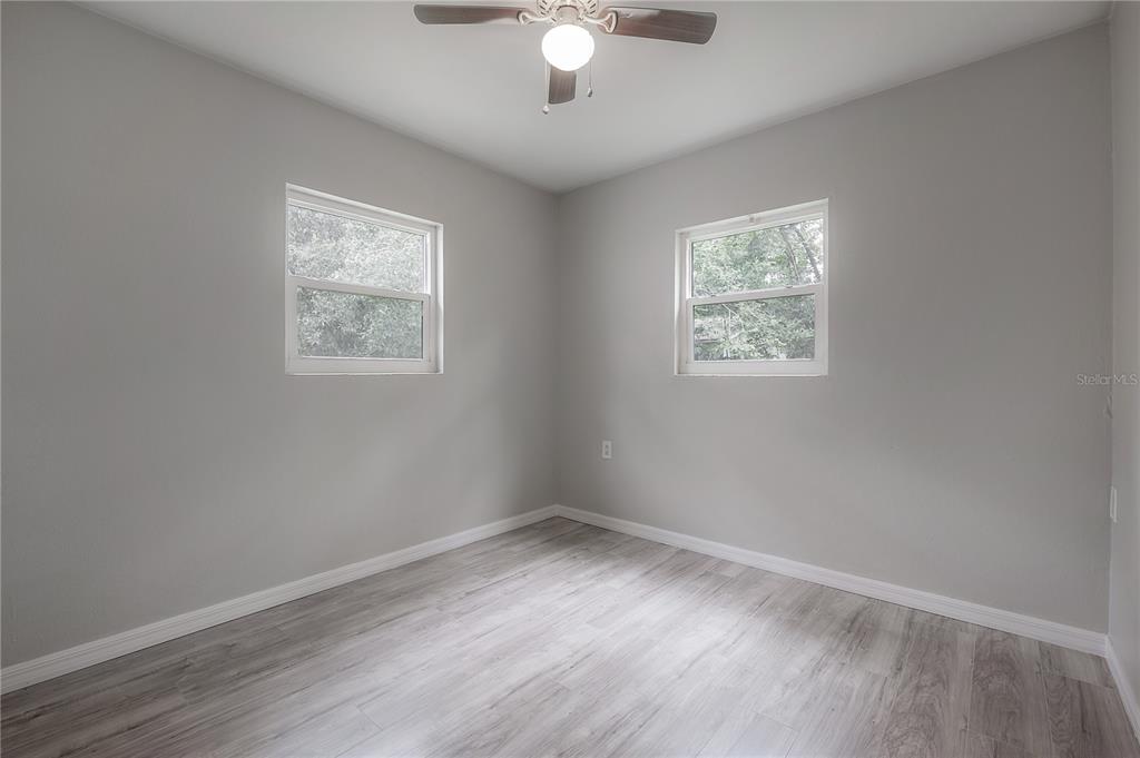 10411 North Woodmere Road Tampa, FL 33617 - Photo 12 of 29 wooden floor in an empty room with a window