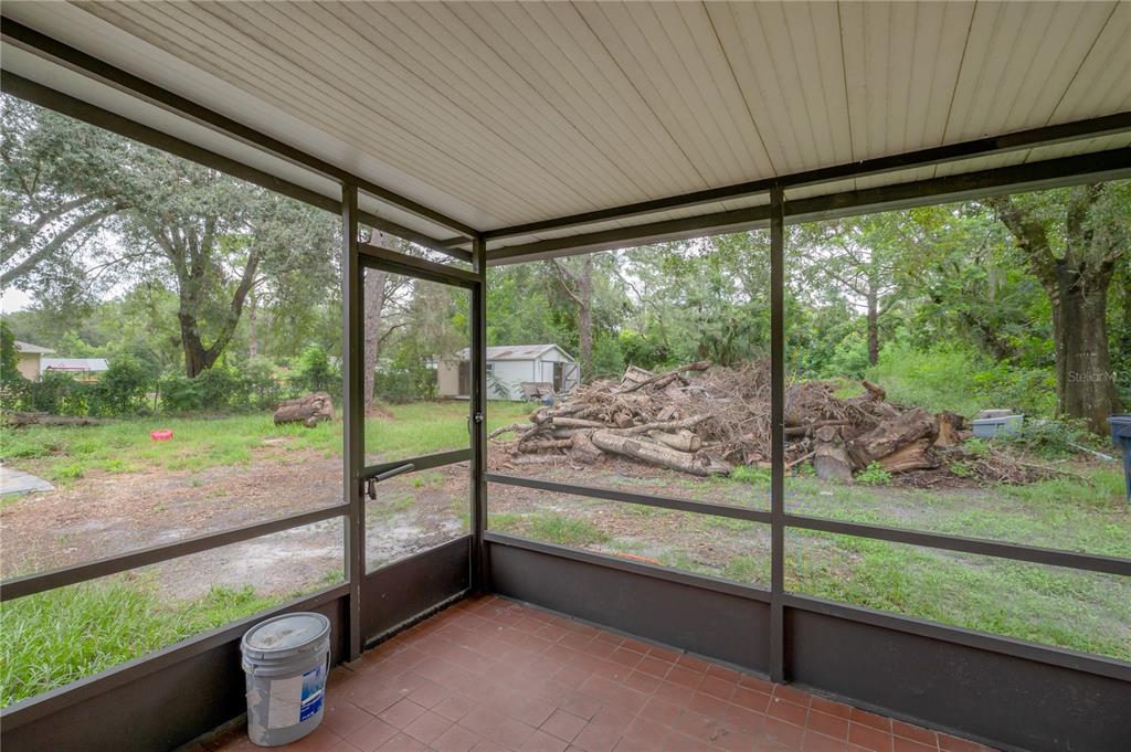 10411 North Woodmere Road Tampa, FL 33617 - Photo 17 of 29 a view of a porch with furniture and garden