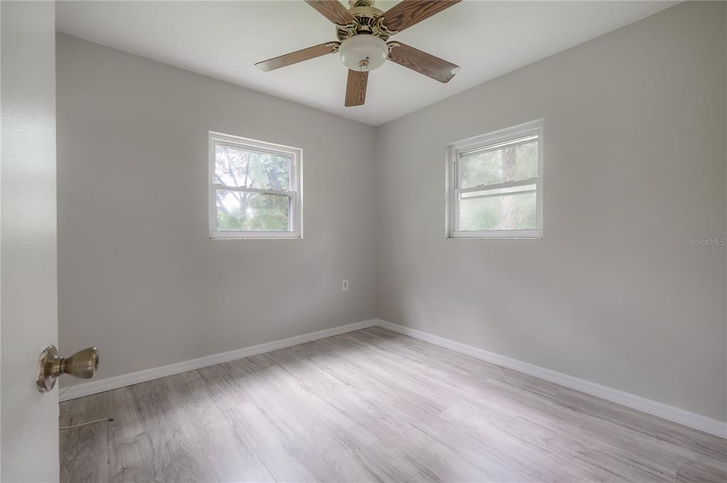 10411 North Woodmere Road Tampa, FL 33617 - Photo 20 of 29 wooden floor in an empty room with a window