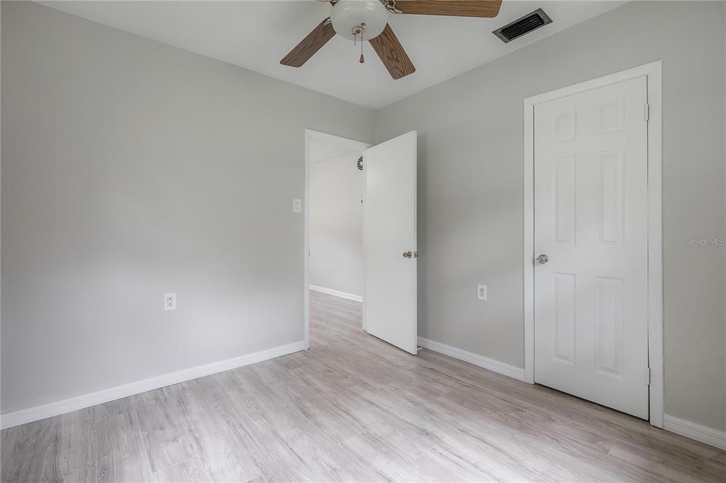 10411 North Woodmere Road Tampa, FL 33617 - Photo 24 of 29 an empty room with wooden floor