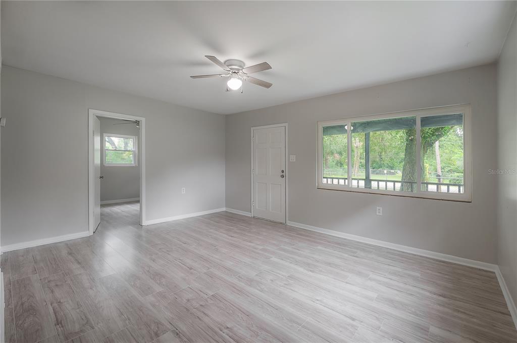 10411 North Woodmere Road Tampa, FL 33617 - Photo 5 of 29 a view of an empty room with wooden floor and a window