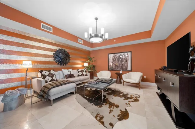 a living room with furniture a flat screen tv and kitchen view