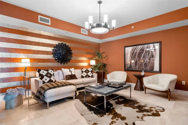 a living room with furniture a chandelier and a rug