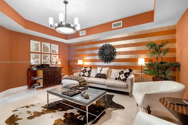 a living room with furniture a chandelier and a dining table
