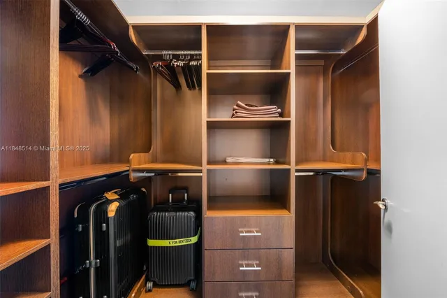 a view of walk in closet with clothes and shoes