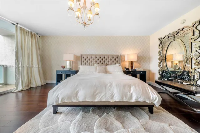 a bedroom with a bed mirror on desk and a window