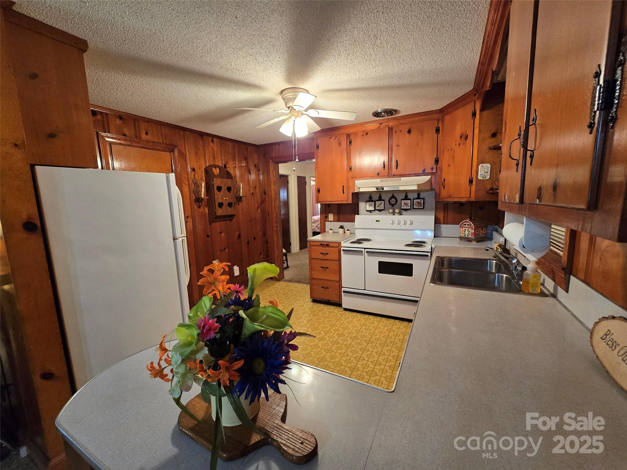 517 Mask Road Mount Gilead, NC 27306 - Photo 11 of 48 a kitchen with stainless steel appliances a stove a refrigerator a sink a dining table and chairs with wooden floor