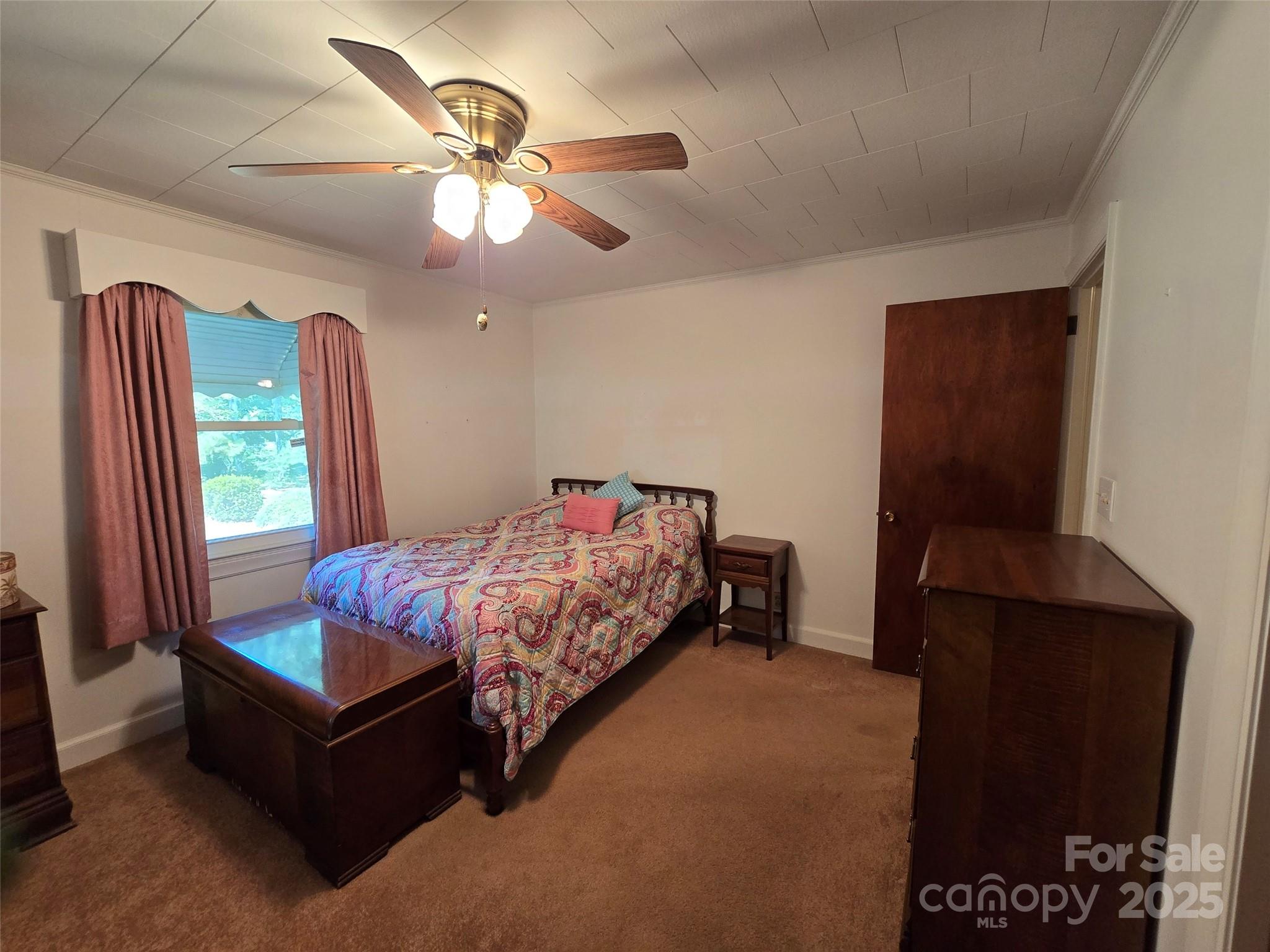 517 Mask Road Mount Gilead, NC 27306 - Photo 15 of 48 a bedroom with a bed and a chandelier