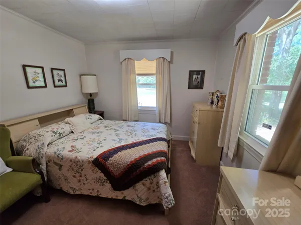 a bedroom with a bed a mirror and a window